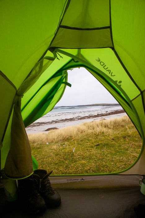 View from a green tent onto a beach.