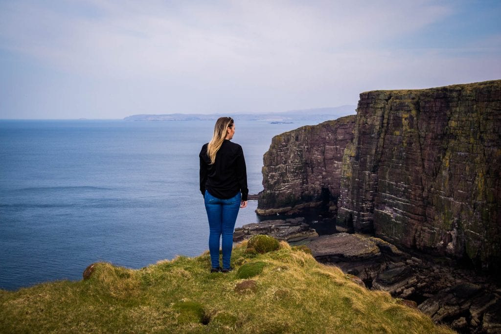 A woman standing by cliffs on Handa Island