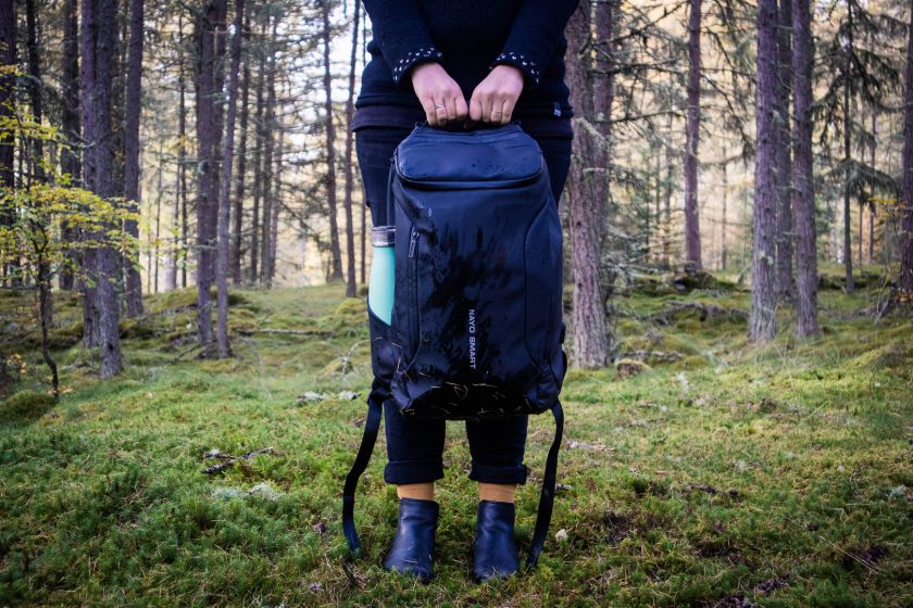 Woman holding a backpack in the forest