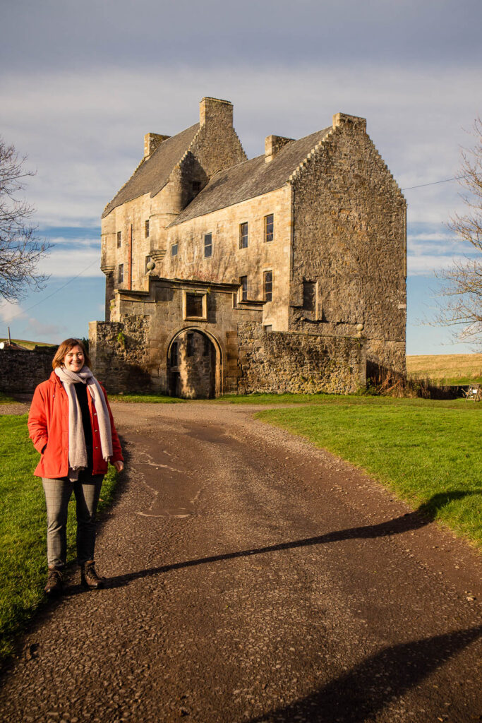 A women standing at Lallybroch castle in Scotland