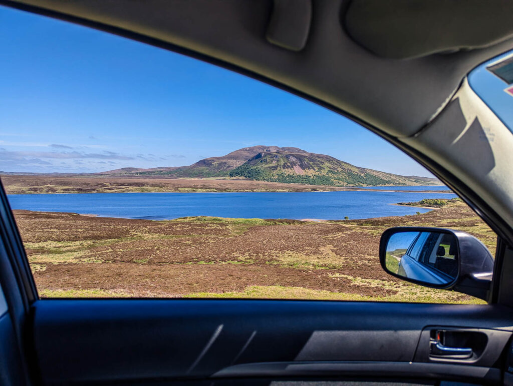 View from my car window onto a loch and mountains