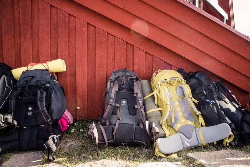 Backpacks in front of a red wall in Sweden. - The best trekking backpacks & their must-have features